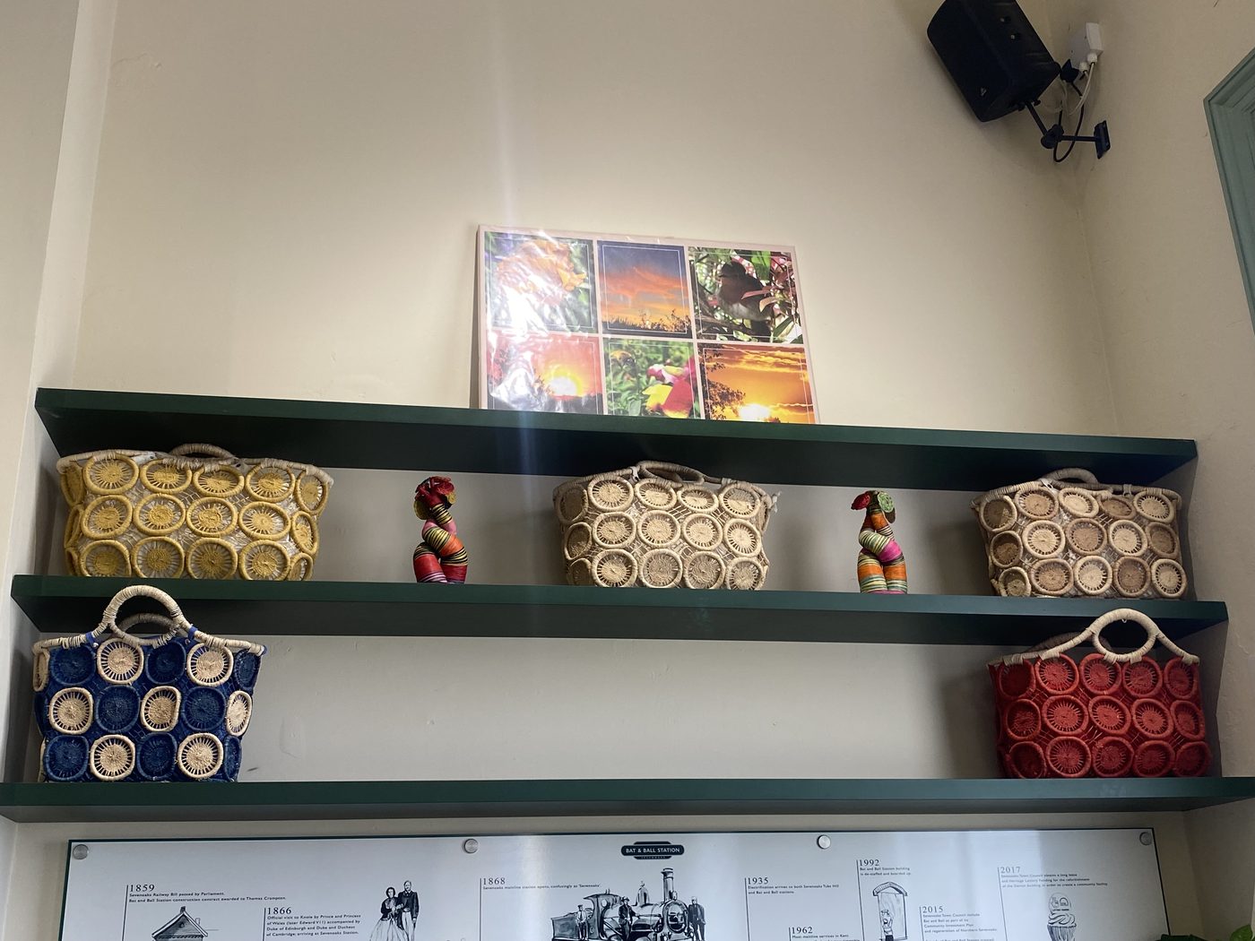 Sage-green shelves of handwoven baskets above the station's heritage timeline, a warm spot to rest
